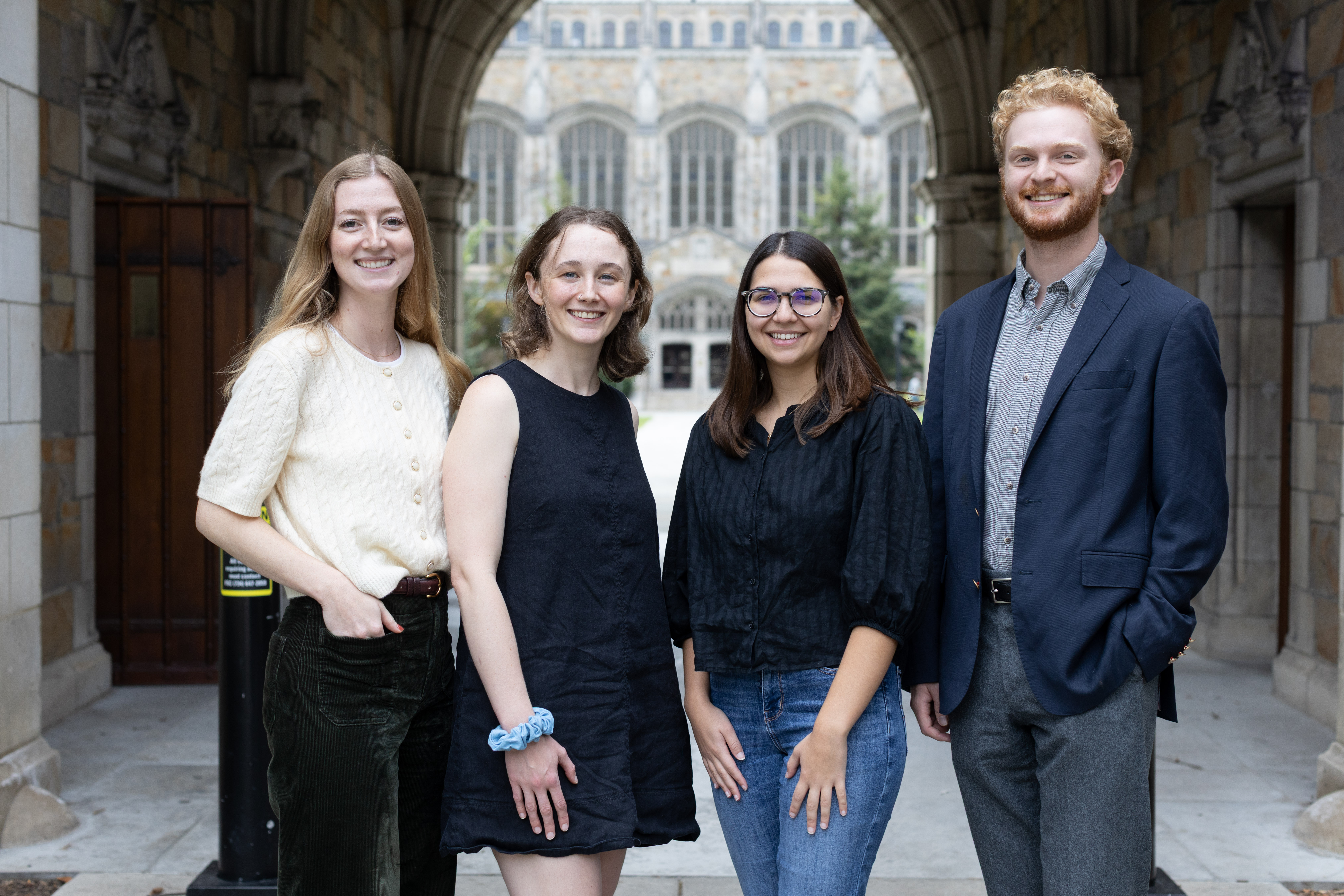 Four law students pose in front of the UM Law Quad
