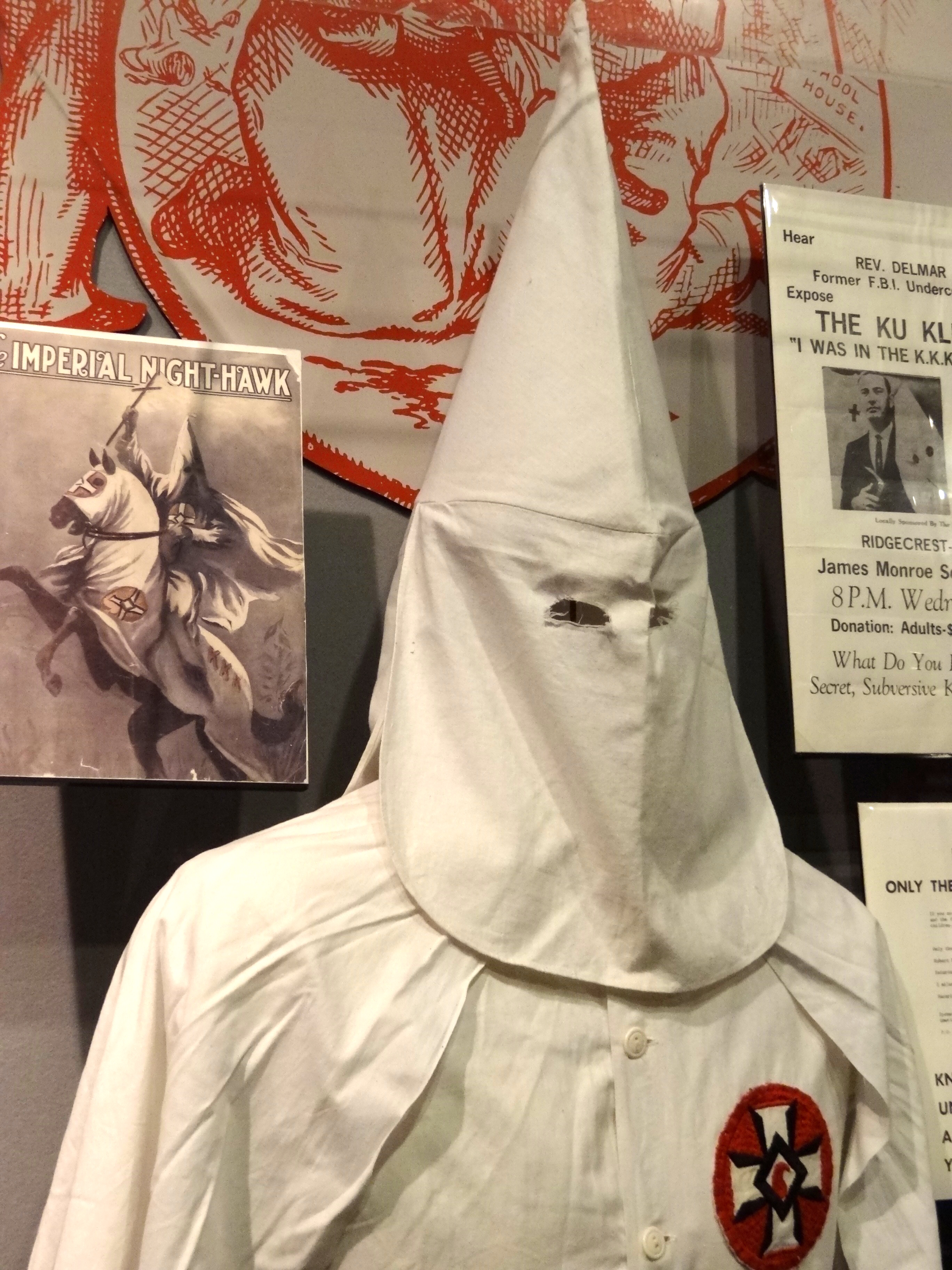 Museum exhibit showing Ku Klux Klan outfit and materials.